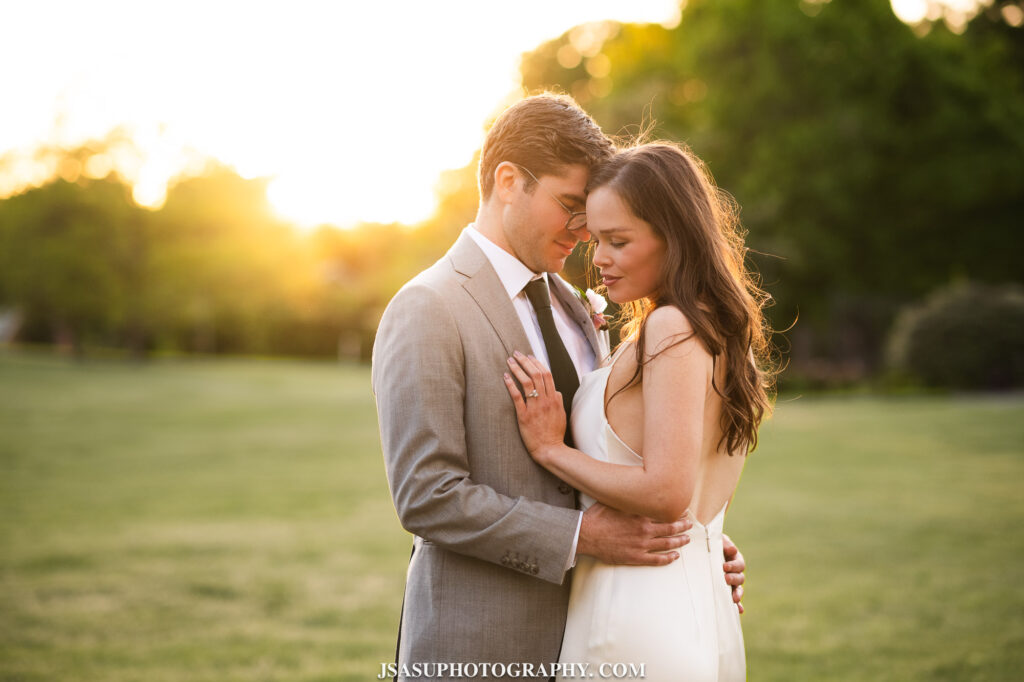 bride and groom taking portraits at sunset