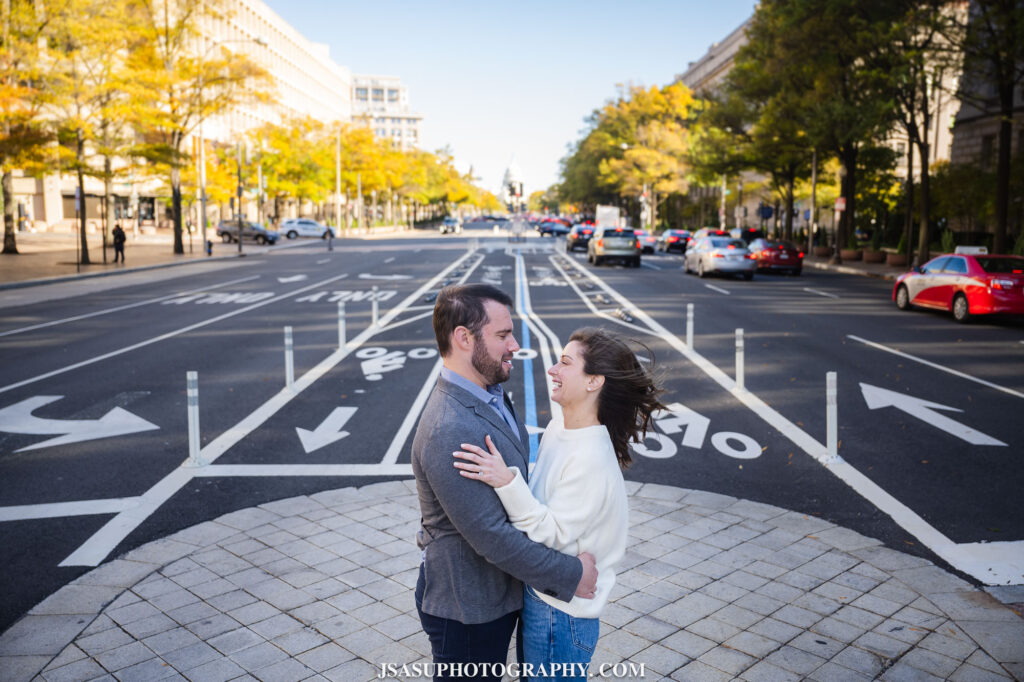 a couple poses for a photo during an engagement session in front of Capitol Hill