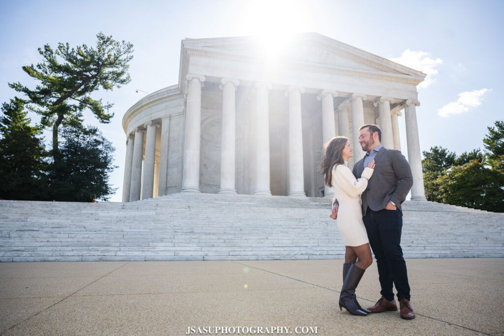 couple posing for their engagement session in front of the thomas jefferson memorial