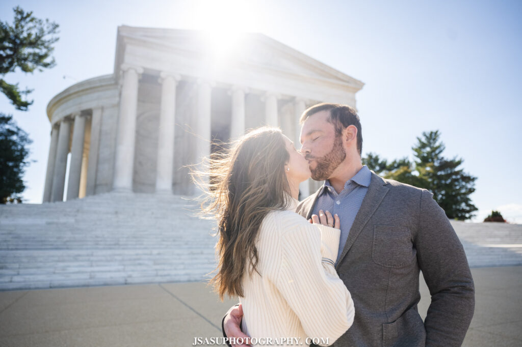 couple kissing in front of thomas Jefferson memorial 
