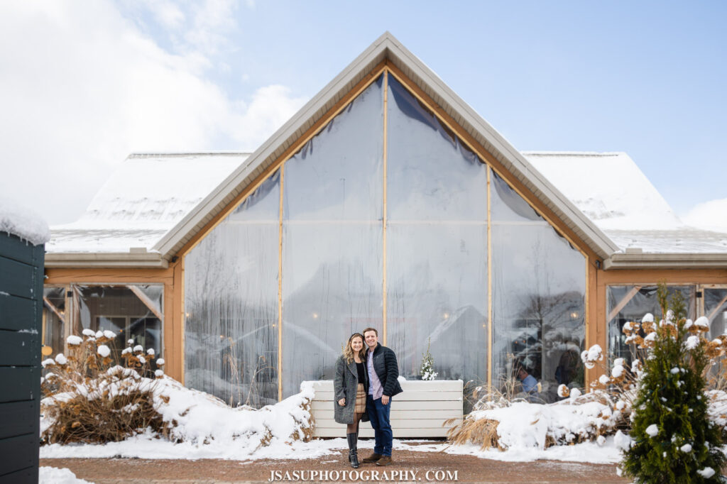 a couple poses in the snow in front of old westminster winery