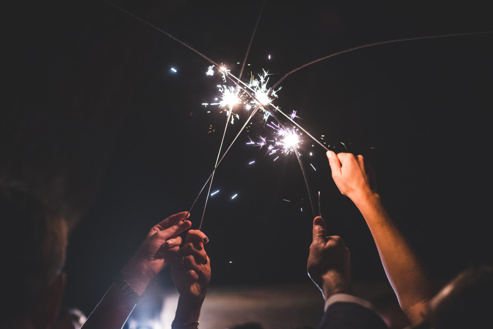 lit sparklers at night after a wedding