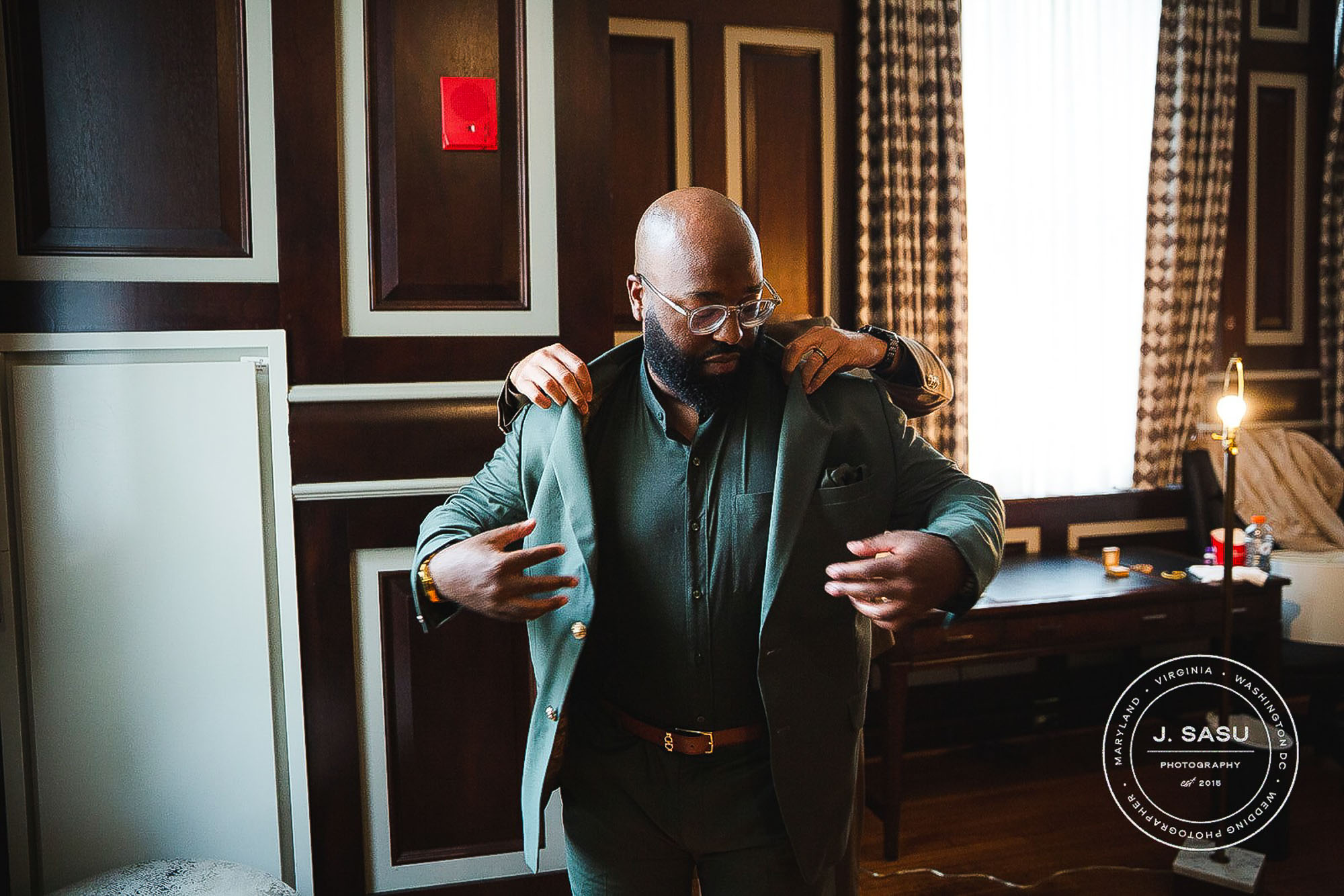 groom putting on his wedding suit