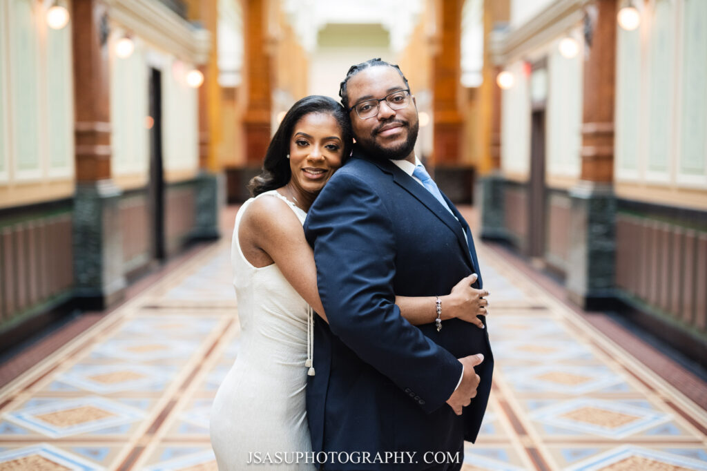 couple posing for photo in the hallway connecting the National Portrait Gallery to the National Gallery of Art. 