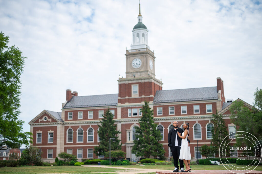 A couple poses for engagement photos in front of the Founder's Library at Howard University in Washington, DC