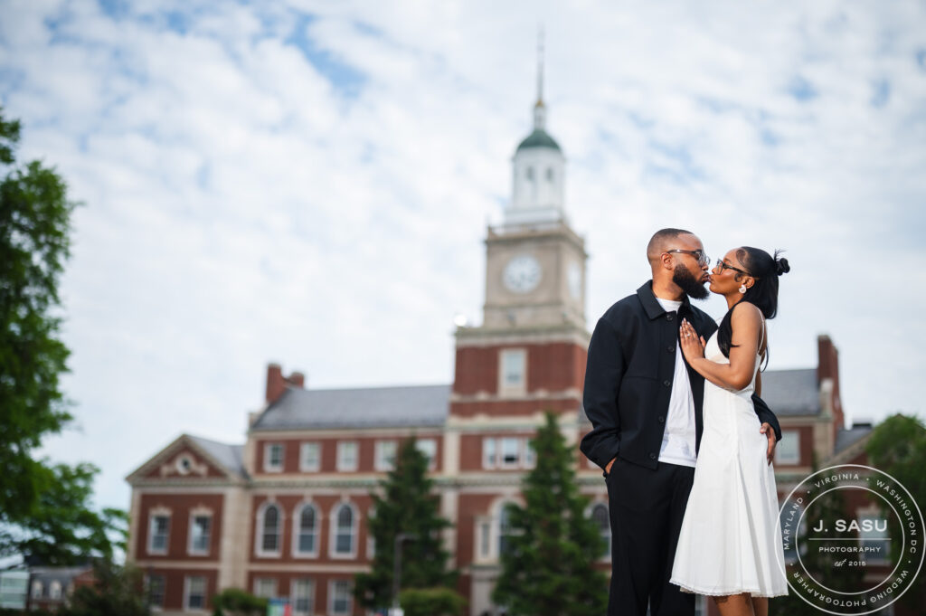 A couple kisses for engagement photos in front of the Founder's Library at Howard University in Washington, DC