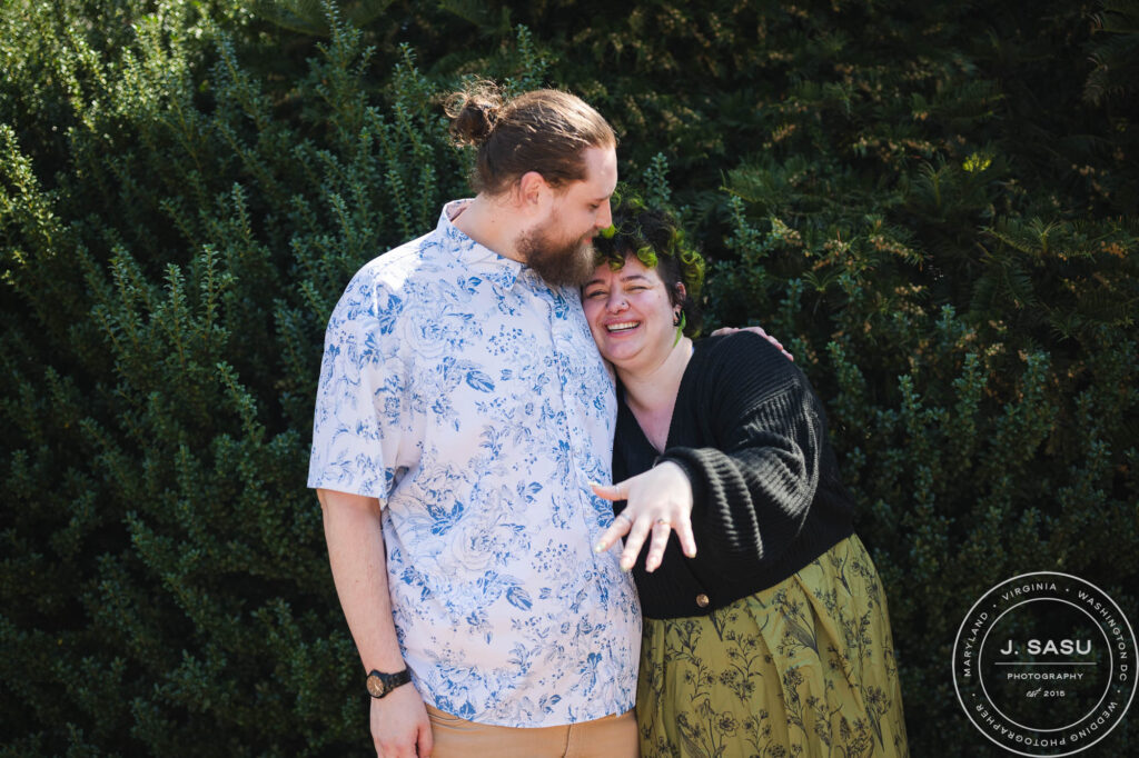 A woman shows her engagement ring during a surprise proposal at the Moongate Garden in the Enid A. Haupt Garden. 