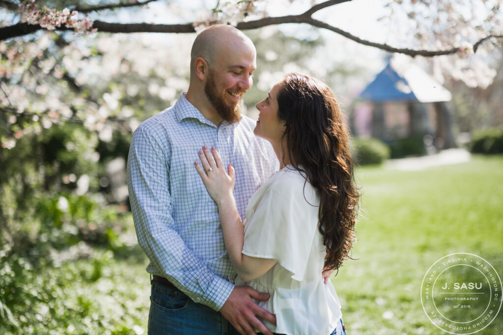 a couple poses for a photo during their engagement session at the bishop's garden in washington dc's national cathedral 