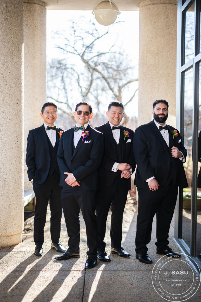 a groom and his groomsmen pose for a photo at the atrium at meadowlark botanical gardens