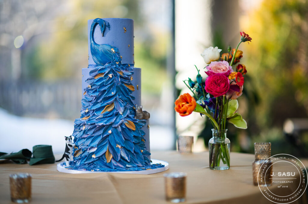 wedding cake atop a table next to flowers at the atrium at meadowlark botanical gardens