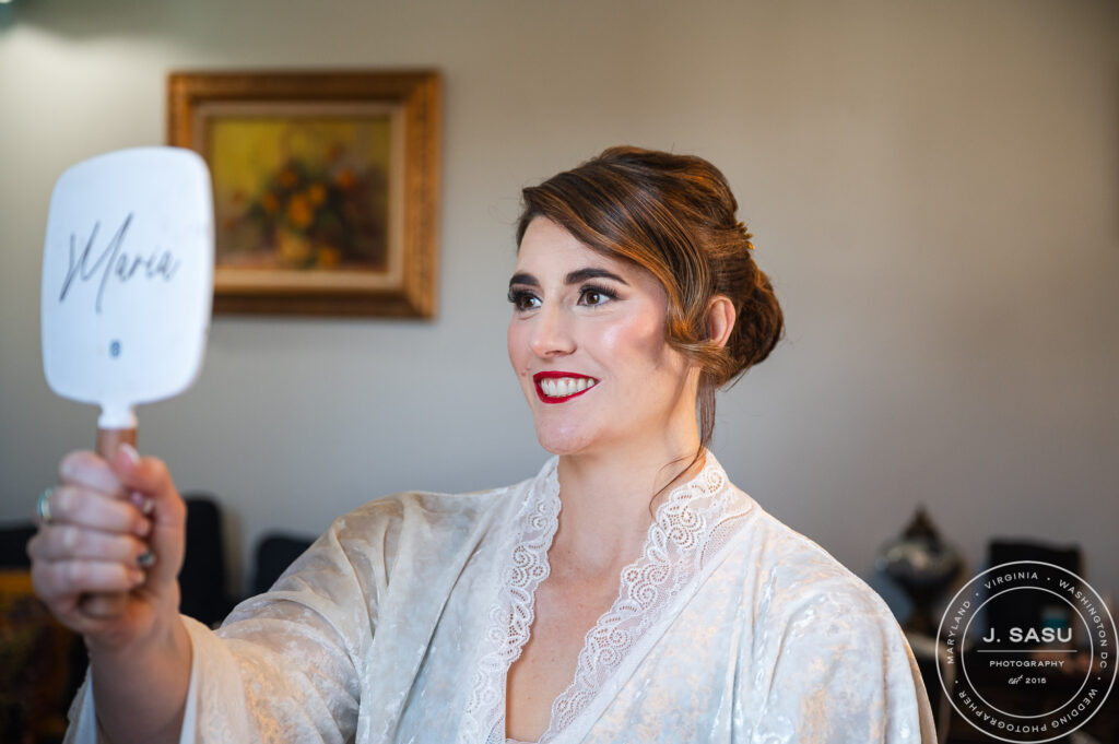 a bride checks her hair and makeup with a mirror