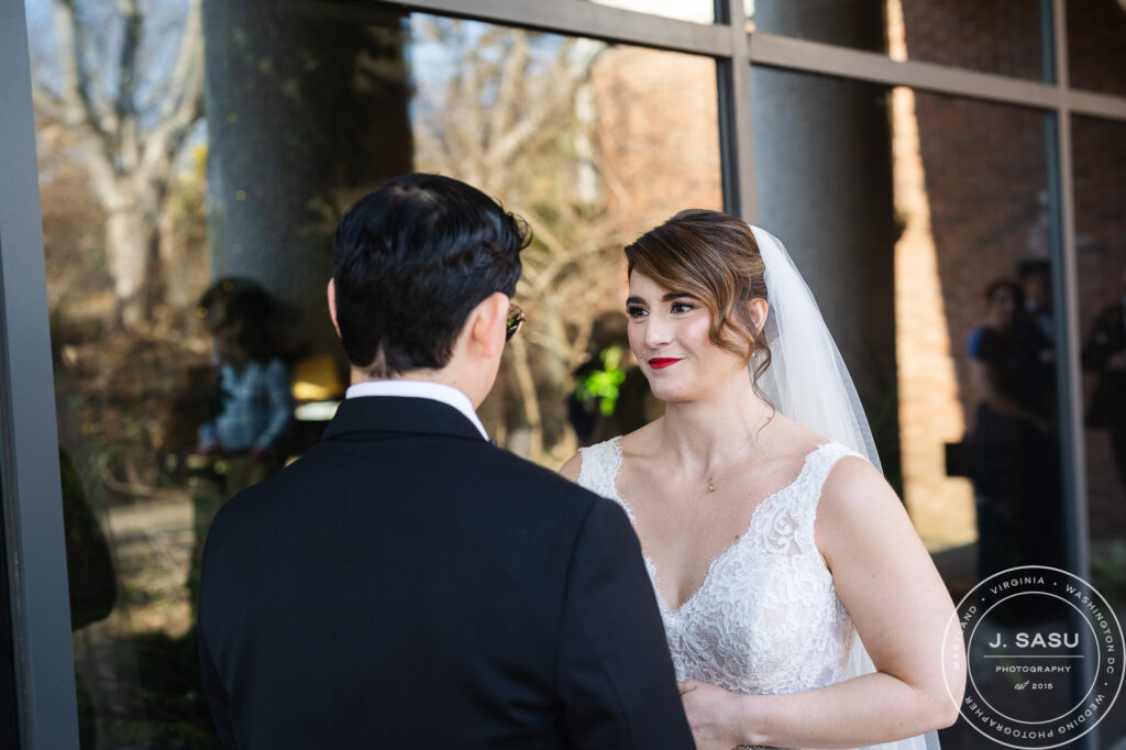 a bride looks towards her partner for the first time on their wedding day at the atrium at meadowlark botanical gardens